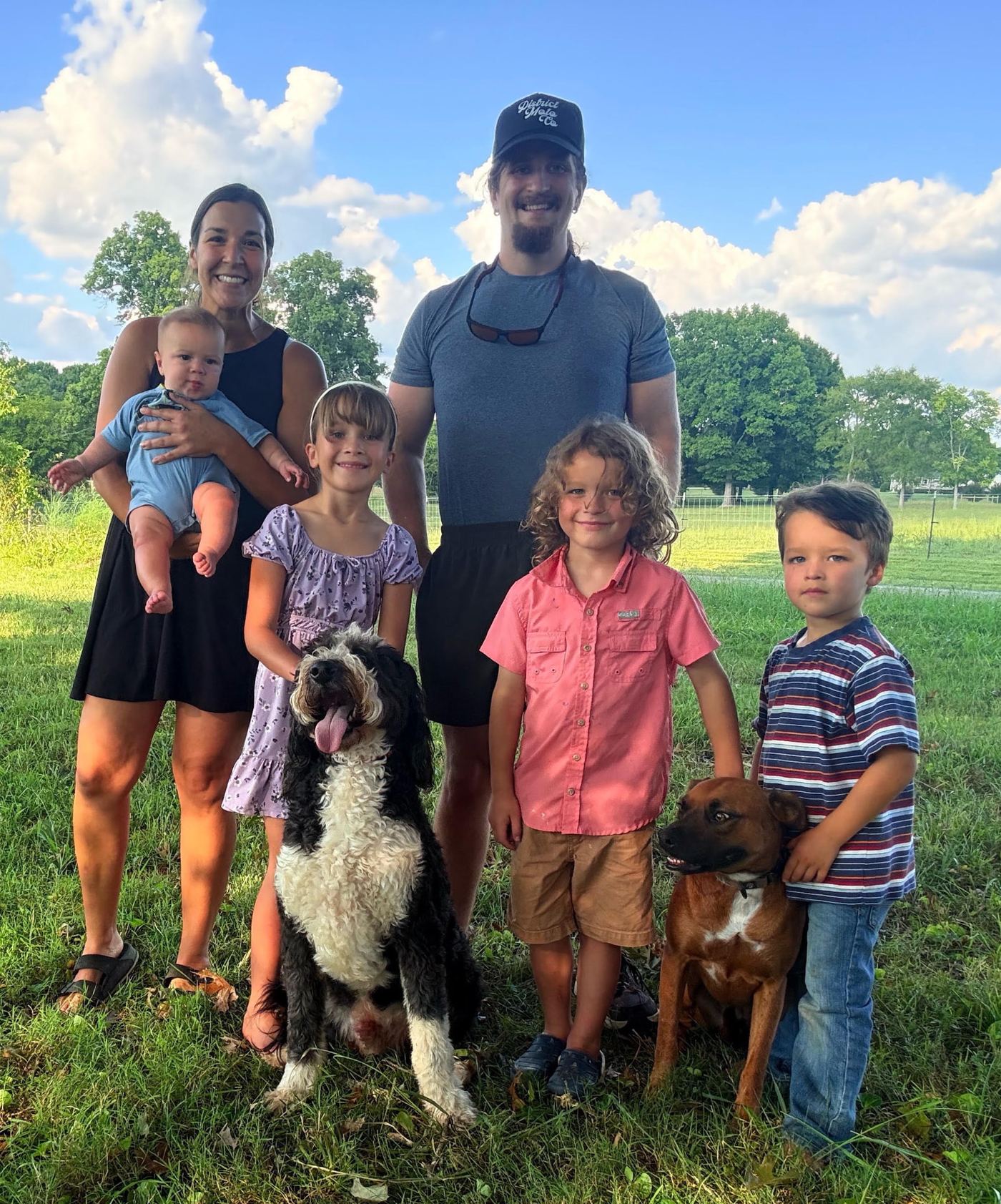 The family behind Devoted Dog Care outside with their two dogs